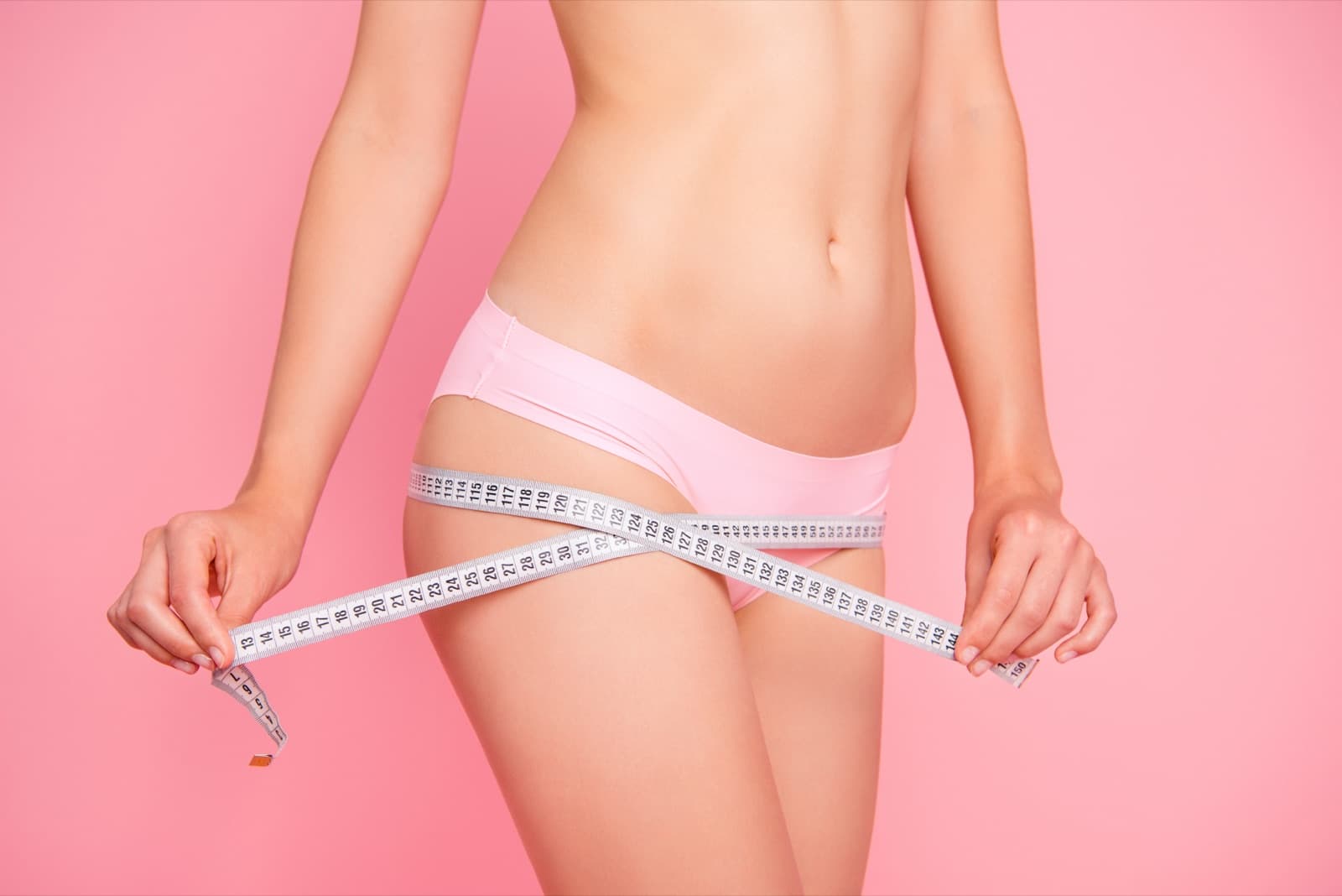 Slim waist with measuring tape after non-surgical fat reduction at FusionMed Toronto